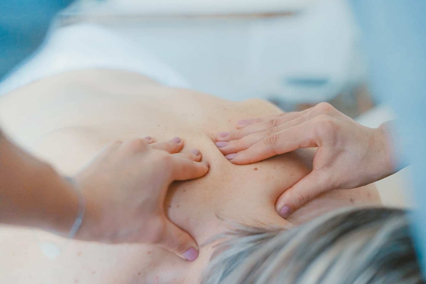 Hands applying massage pressure to a back